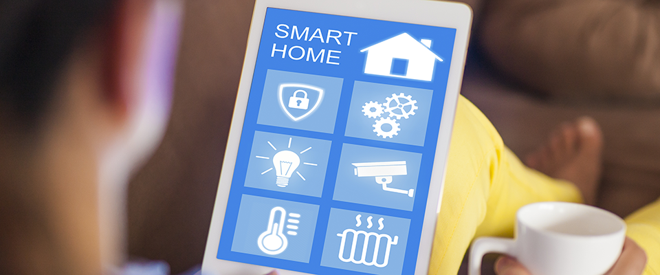 Woman controlling home using wireless tablet while relaxing on sofa.